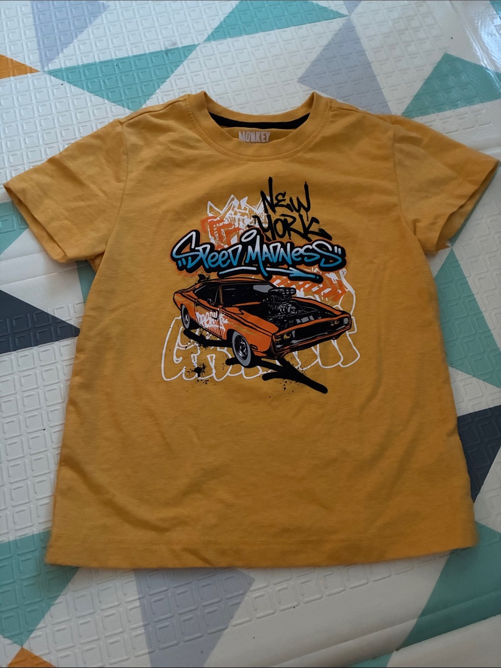 20/25$ 🧸 Kids "Street Madness" Graphic Tee in Mustard